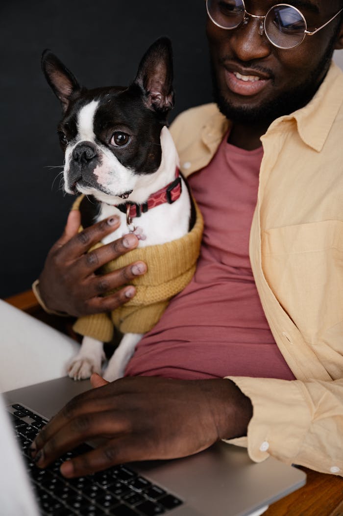 Crop black man with laptop and dog